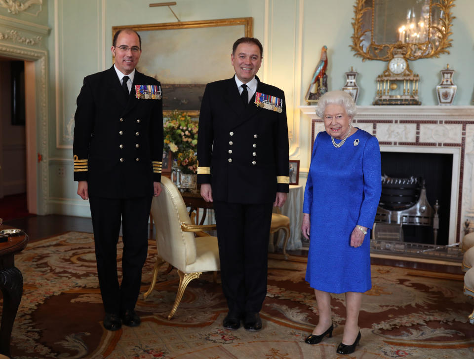 LONDON, ENGLAND - MARCH 18: Queen Elizabeth II receives Commodore Steven Moorhouse (centre, outgoing Commanding Officer, HMS Queen Elizabeth) and Captain Angus Essenhigh (incoming Commanding Officer), during a private audience in the Queens Private Audience Room in Buckingham Palace on March 18, 2020 in London, England. (Photo by Yui Mok - WPA Pool/Getty Images)