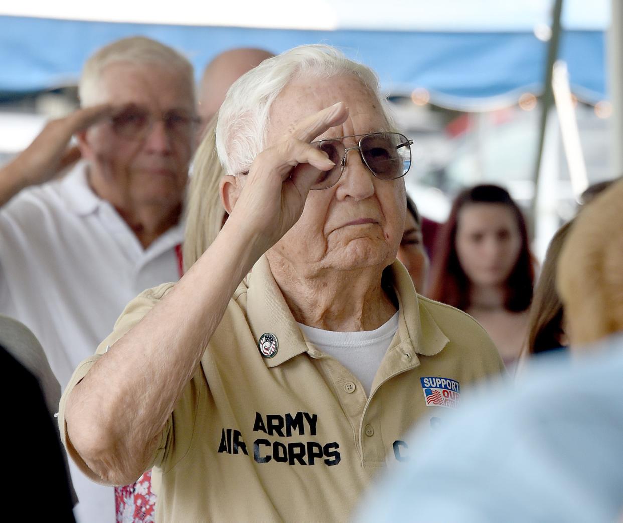 Army veteran Carl Smalley, 99, salutes Monday during the national anthem sung by 2022 Miss Monroe County Payton Perry-Radcliffe at the Monroe County Fair Veterans Day program.
