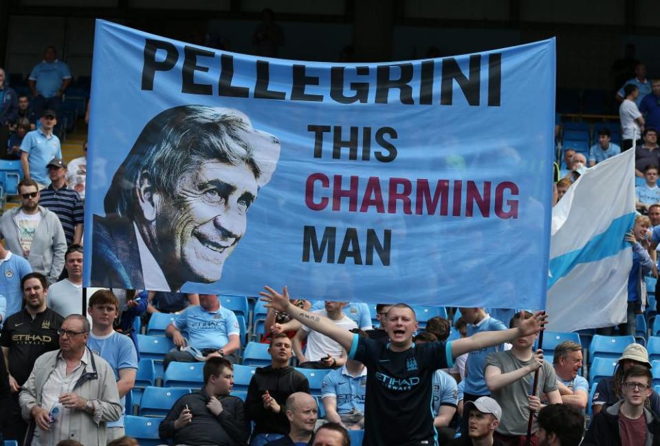 Manchester City’s supporters hold a banner with the image of Manuel Pellegrini