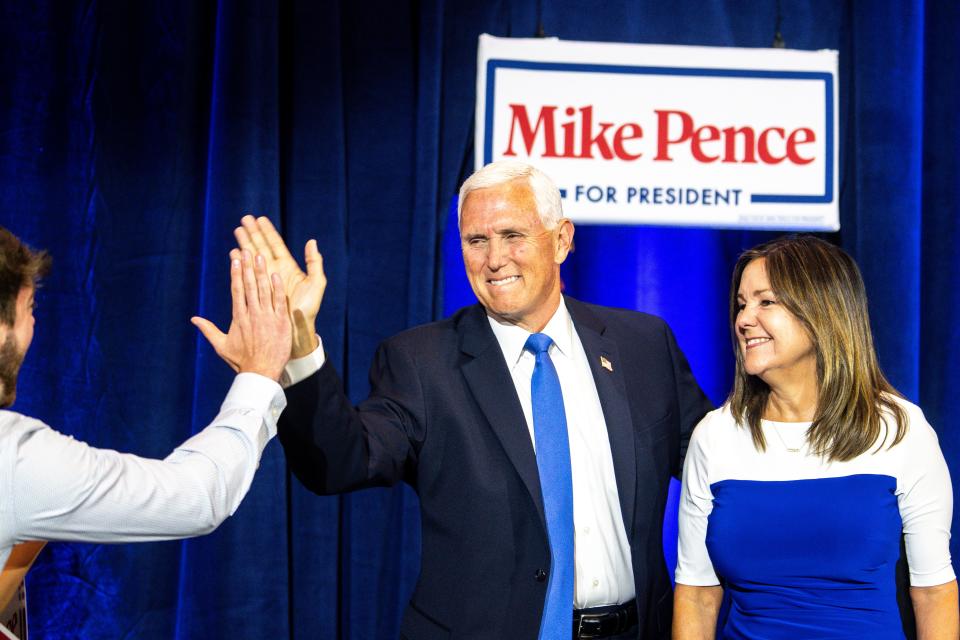 Former Vice President Mike Pence high fives a fan as he and former second lady Karen Pence take the stage for his presidential campaign kickoff in Ankeny, Iowa, on June 7, 2023.