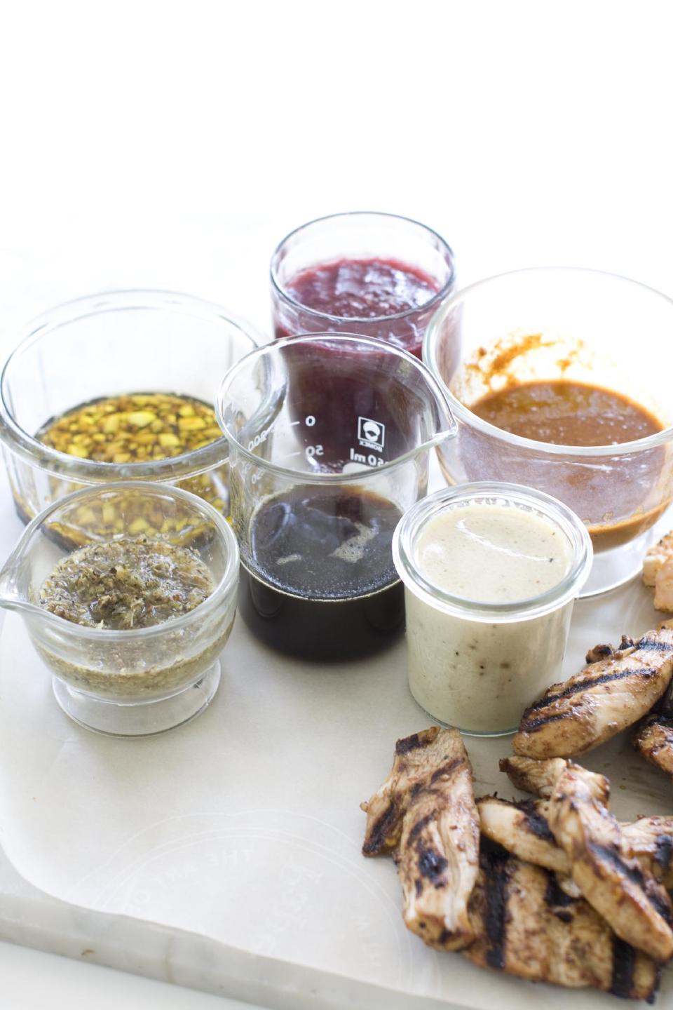 This July 29, 2013 photo shows, from left, marinades of lemon herb, garlic balsamic, maple soy, raspberry ginger, white wine mustard and orange cumin in Concord, N.H. On the meat, from top, are chipolte lime, red wine and rosemary and spicy hoisin. (AP Photo/Matthew Mead)