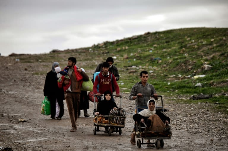 Residents evacuate a West Mosul district during the offensive to retake the city from Islamic State group, on March 16, 2017