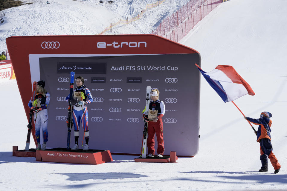 From left, second placed United States' Mikaela Shiffrin, winner France's Romane Miradoli and third placed Switzerland's Lara Gut Behrami celebrate on the podium an alpine ski, women's World Cup super-G, in Lenzerheide, Switzerland, Saturday, March 5, 2022. (AP Photo/Giovanni Auletta)