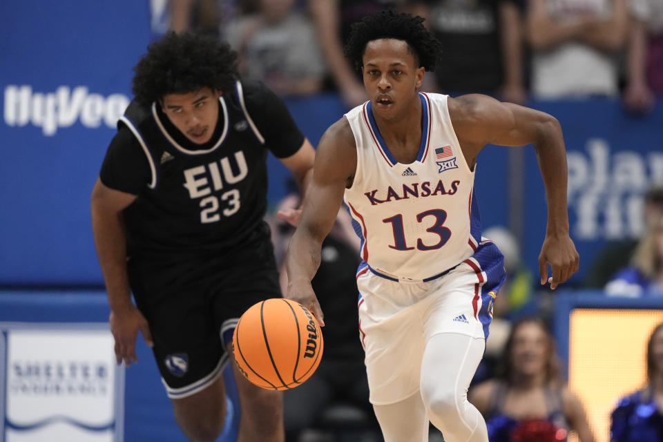 Kansas guard Elmarko Jackson (13) is chased by Eastern Illinois forward Rodolfo Bolis (23) as he drives with the ball during the first half of an NCAA college basketball game Tuesday, Nov. 28, 2023, in Lawrence, Kan. (AP Photo/Charlie Riedel)