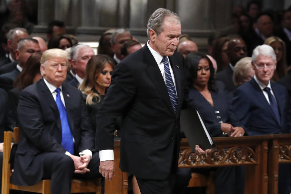 Former President George W. Bush walks past President Donald Trump, first lady Melania Trump, Michelle Obama and former President Bill Clinton to give a eulogy for his father, former President George H.W. Bush during the State Funeral at the National Cathedral, Wednesday, Dec. 5, 2018, in Washington. (AP Photo/Alex Brandon, Pool)