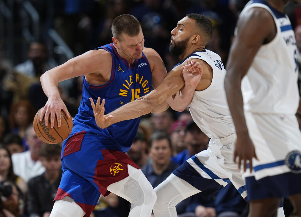 Denver Nuggets center Nikola Jokic, left, drives to the basket as Minnesota Timberwolves center Rudy Gobert defends in the second half of Game 1 of an NBA basketball second-round playoff series Saturday, May 4, 2024, in Denver. (AP Photo/David Zalubowski)