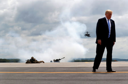 U.S. President Donald Trump observes a demonstration with U.S. Army 10th Mountain Division troops, an attack helicopter and artillery as he visits Fort Drum, New York, U.S., August 13, 2018. Reuters photographer Carlos Barria: "President Trump often talks about how much he likes big planes and tanks, and the 'beautiful military.' This summer he had a up-close look during a visit to a military base in New York state, where he signed the National Defense Authorization Act." REUTERS/Carlos Barria