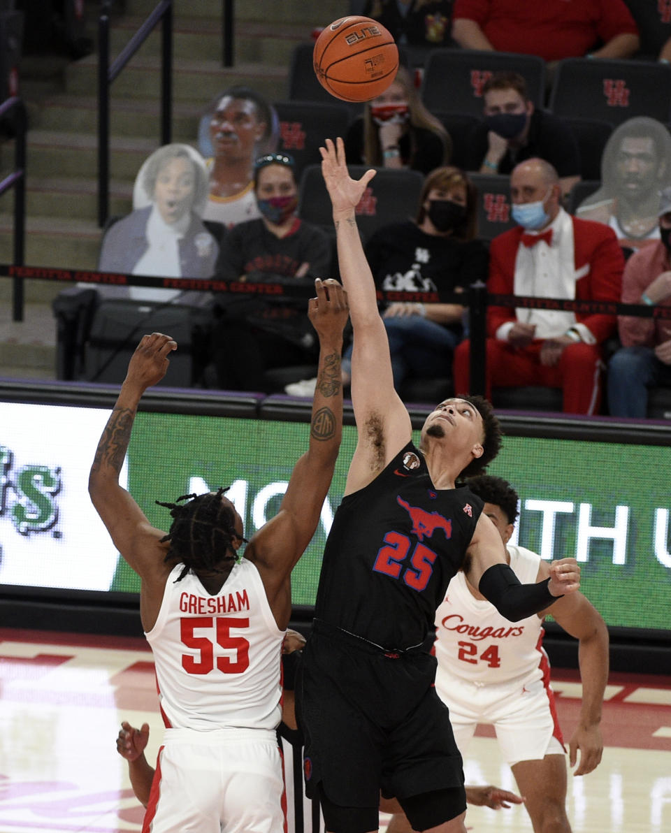 SMU forward Ethan Chargois (25) reaches for the opening tipoff over Houston forward Brison Gresham (55) during the first half of an NCAA college basketball game, Sunday, Jan. 31, 2021, in Houston. (AP Photo/Eric Christian Smith)