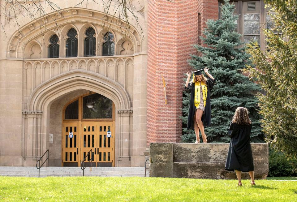 University of Idaho senior Natalie Fischer, right, takes graduation photos of classmate Rebecca Buratto on Friday, April 24, 2020, outside the university's administration building in Moscow, Idaho.