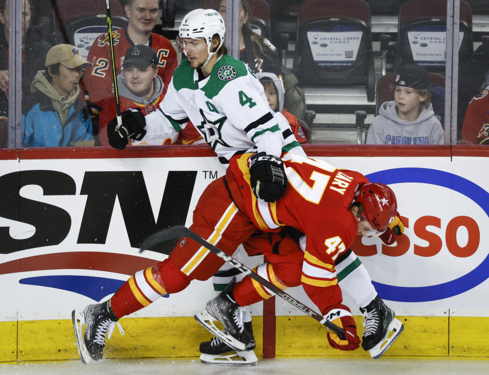 Dallas Stars defenseman Miro Heiskanen, left, is checked by Calgary Flames forward Connor Zary during the first period of an NHL hockey game, Wednesday, Nov. 1, 2023 in Calgary, Alberta. (Jeff McIntosh/The Canadian Press via AP)