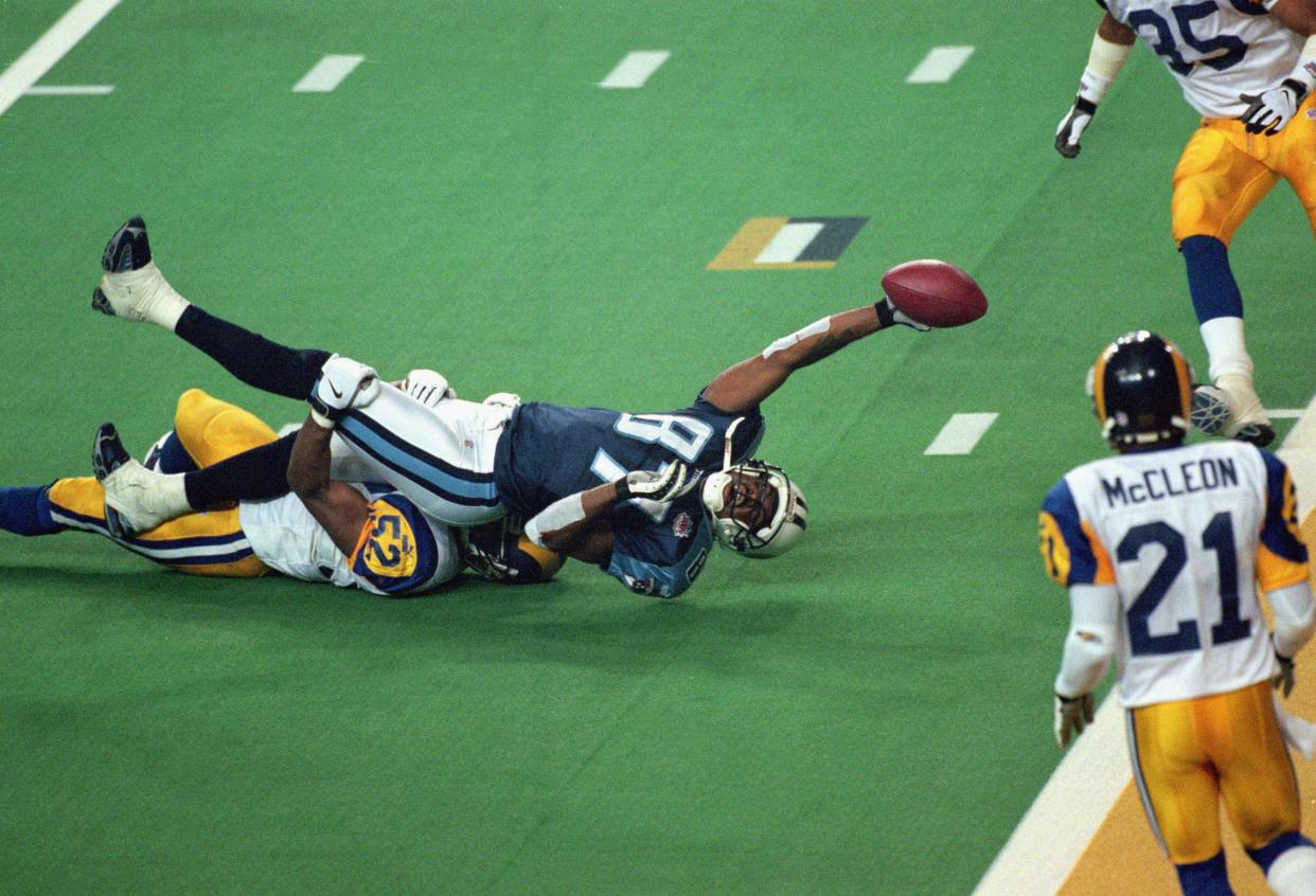 Kevin Dyson #87 of the Tennessee Titans reaches for the end zone with the ball as Mike Jones #52 of the St. Louis Rams tackles him on the last play of the game during the Super Bowl XXXIV Game at the Georgia Dome on January 30, 2000
