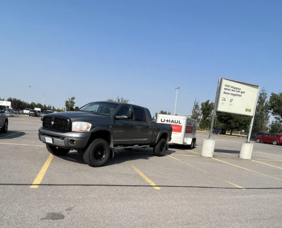 A truck and U-Haul taking up several parking spots