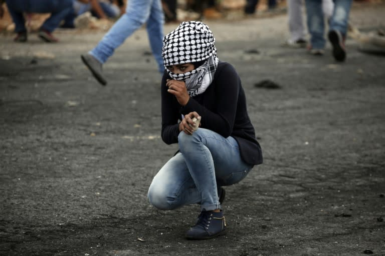 A Palestinian woman from Birzeit University looks on during clashes with Israeli security forces in Beit El, on the outskirts of the West Bank city of Ramallah, on October 7, 2015