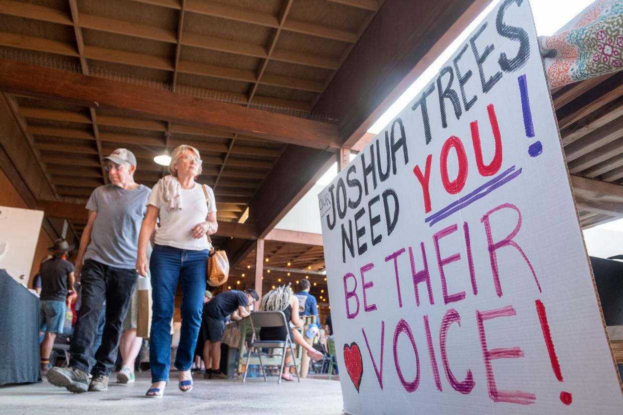 People visit information booths during the Mojave Desert Land Trust's "Save the Western Joshua Tree" rally at the trust headquarters in Joshua Tree, Calif., on May 26, 2022.