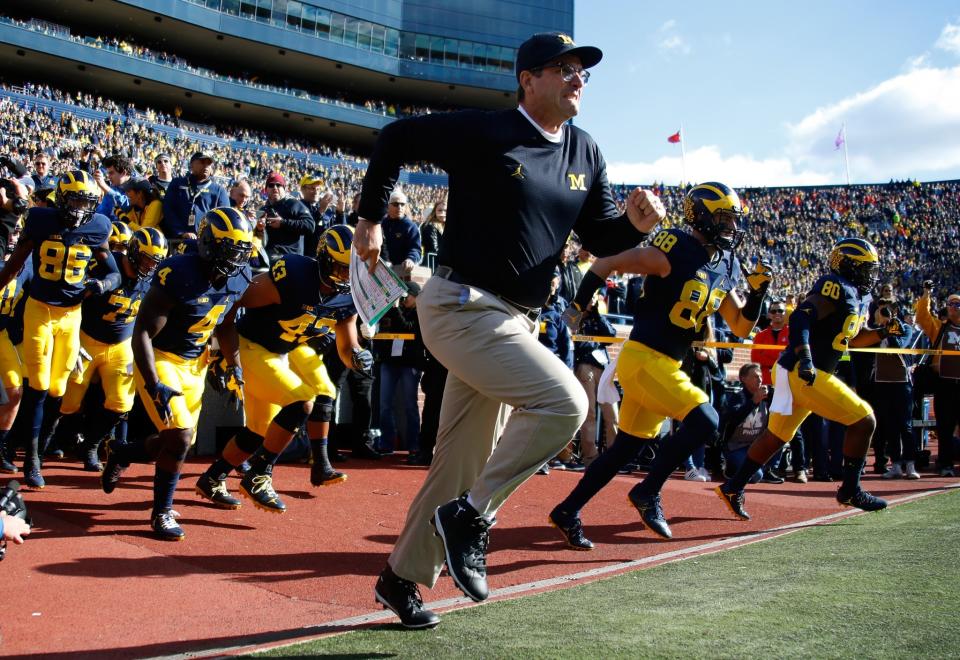 Jim Harbaugh doesn’t run in khakis only on game days. (Getty)