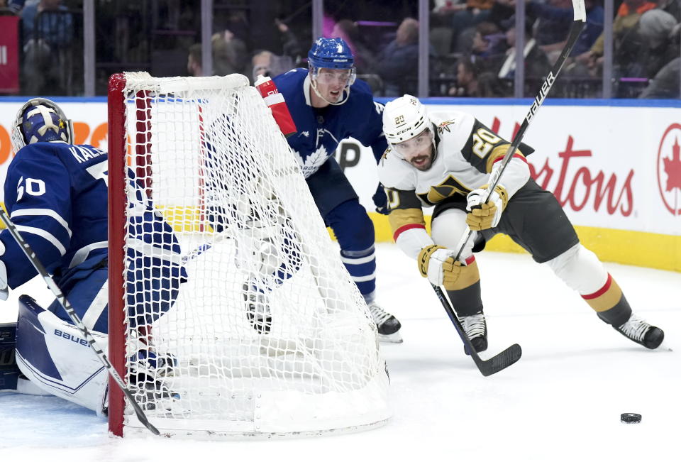 Vegas Golden Knights forward Chandler Stephenson (20) chases down the loose puck against Toronto Maple Leafs defenseman Justin Holl (3) during the third period of an NHL hockey game, Tuesday, Nov. 8, 2022 in Toronto. (Nathan Denette/The Canadian Press via AP)