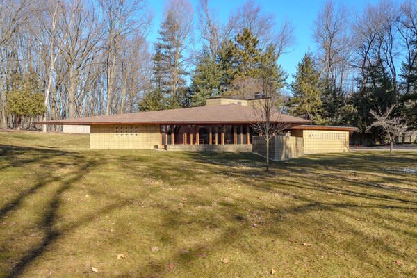 The historic home is dressed in a neutral palette of cement, wood, and glass.