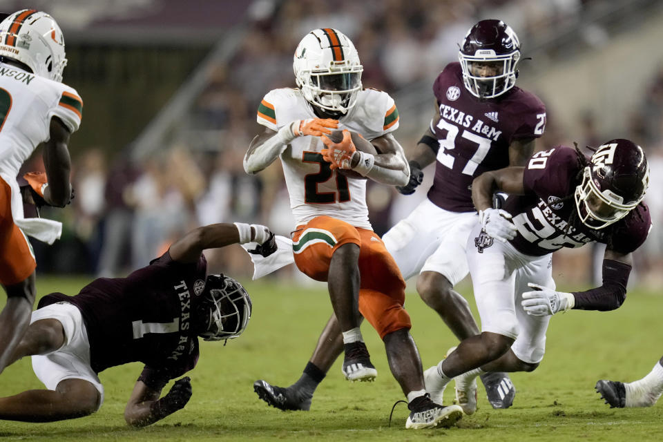 Miami running back Henry Parrish Jr. (21) spins out of a tackle attempt between Texas A&M's Bryce Anderson (1) and Jardin Gilbert (20) during the second quarter of an NCAA college football game Saturday, Sept. 17, 2022, in College Station, Texas. (AP Photo/Sam Craft)