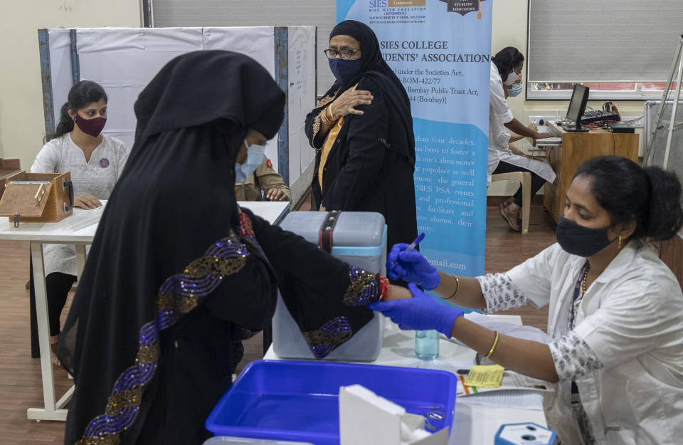 A woman hold her arm after receiving Covishield COVID-19 vaccine at a vaccination center in Mumbai, India, Monday, Nov. 29, 2021. The emergence of the new omicron variant and the world’s desperate and likely futile attempts to keep it at bay are reminders of what scientists have warned for months: The coronavirus will thrive as long as vast parts of the world lack vaccines. (AP Photo/Rafiq Maqbool)