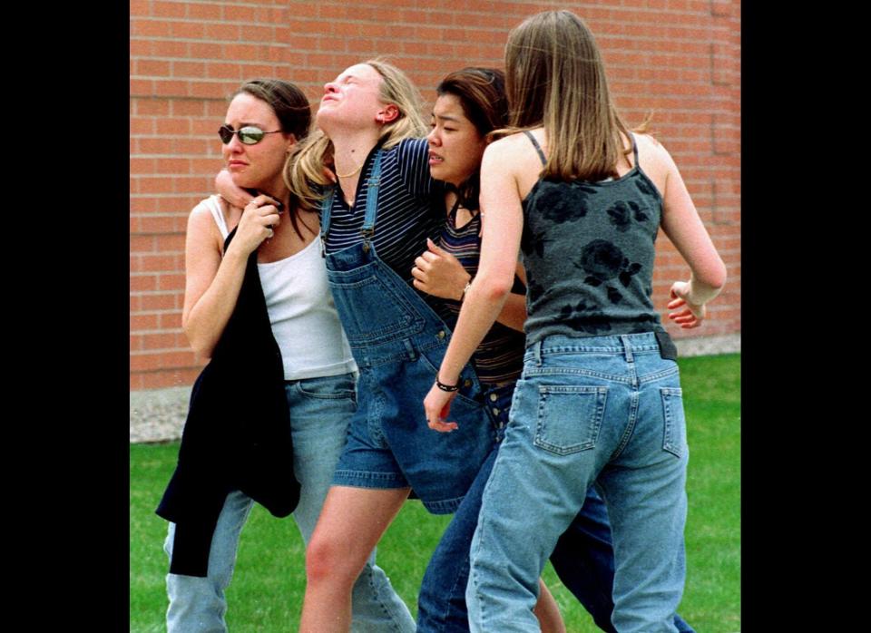 Two heavily armed teenagers go on a rampage at Columbine High School in Littleton, Denver, shooting 13 students and staff before taking their own lives.  <br><em>Caption: In an April 20, 1999, file photo unidentified young women head to a library near Columbine High School where students and faculty members were evacuated after two gunmen went on a shooting rampage in the school in the southwest Denver suburb of Littleton, Colo. (AP Photo/Kevin Higley/file)</em>