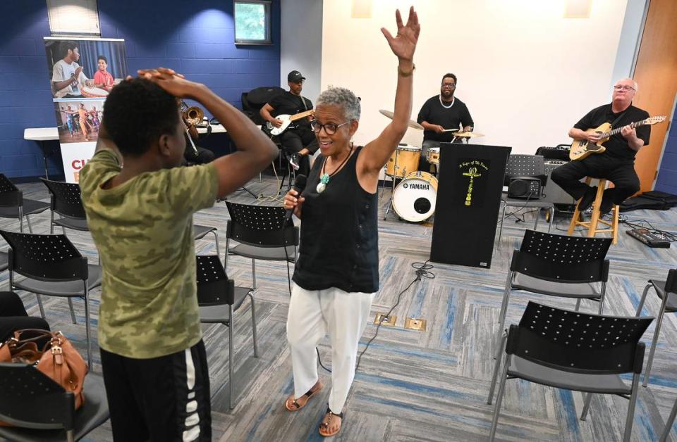 Toni Tupponce enlists the help of 12-year-old Robert Hood to dance as A Sign of the Times performed at the West Boulevard Library.