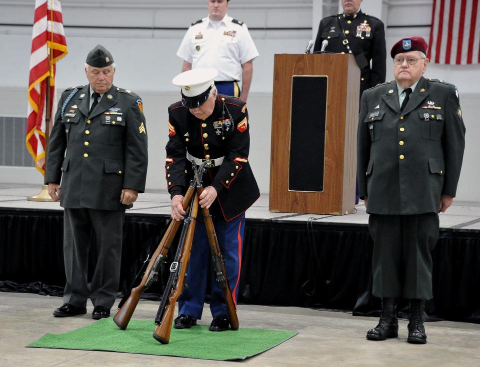 Francis Buckley, Army; Arch Fuller, Marines; and Nevin Nussbaum, Army set up a rifle tribute for the Wayne County Veterans Day event.