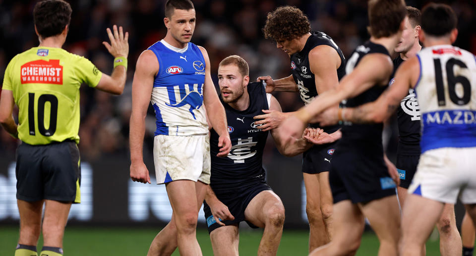 Seen here, Carlton's Harry McKay is helped to his feet after being crunched in a collision against North Melbourne. 