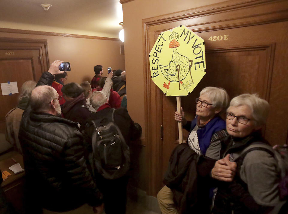 Attendees of a public hearing on an extraordinary session bill submitted by the state's Republicans wait to enter the chambers of the hearing at the Wisconsin State Capitol in Madison, Wis., Monday, Dec. 3, 2018. (John Hart/Wisconsin State Journal via AP)