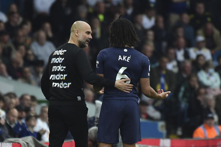 Manchester City's head coach Pep Guardiola, left, and Manchester City's Nathan Ake during the English Premier League soccer match between Leeds United and Manchester City at Elland Road in Leeds, England, Saturday, April 30, 2022. (AP Photo/Rui Vieira)