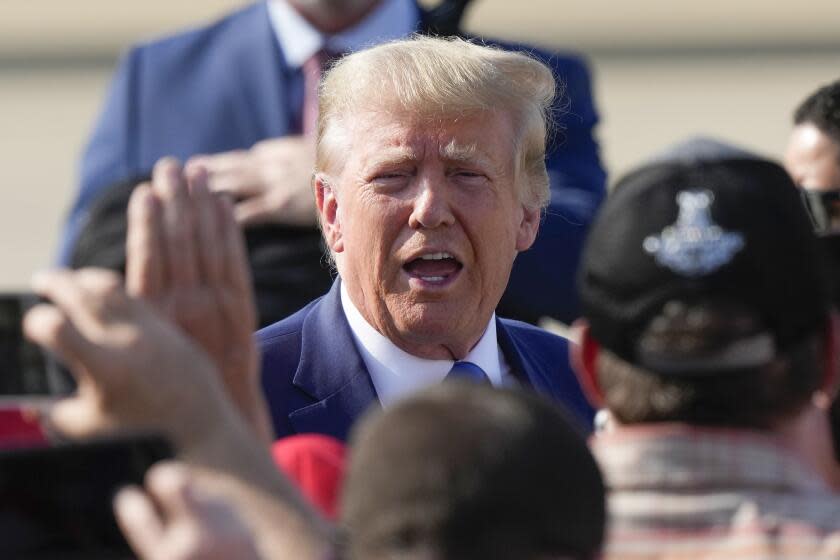 Former President Donald Trump greets supporters as he arrives at New Orleans International Airport in New Orleans, Tuesday, July 25, 2023. (AP Photo/Gerald Herbert)