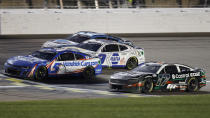 Kyle Larson (5) crosses the finish line milliseconds in front of Chris Buescher (17) for the win during a NASCAR Cup Series auto race at Kansas Speedway in Kansas City, Kan., Sunday, May 5, 2024. (AP Photo/Colin E. Braley)