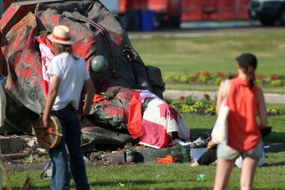 A defaced statue of Queen Victoria lies after being toppled during a rally, following the discovery of the remains of hundreds of children at former indigenous residential schools, outside the provincial legislature on Canada Day in Winnipeg, Manitoba, Canada July 1, 2021.  REUTERS/Shannon VanRaes     TPX IMAGES OF THE DAY