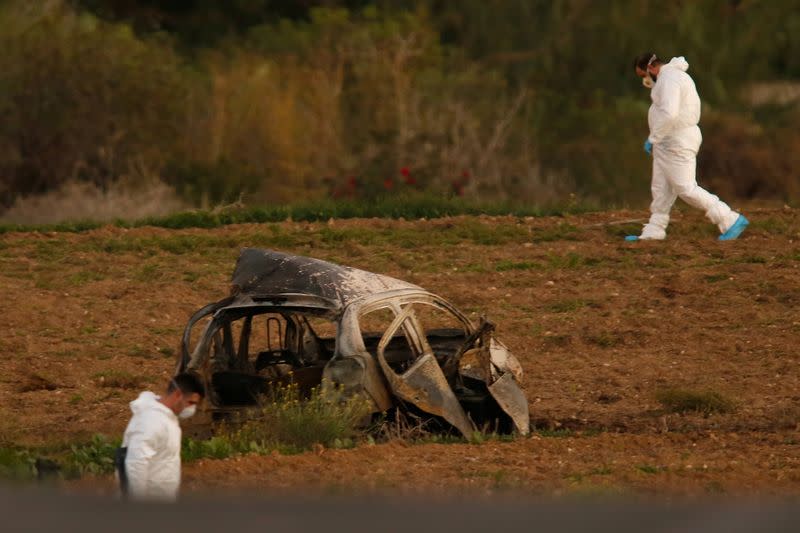 FILE PHOTO: Forensic experts walk in a field after a powerful bomb blew up a car killing investigative journalist Daphne Caruana Galizia in Bidnija