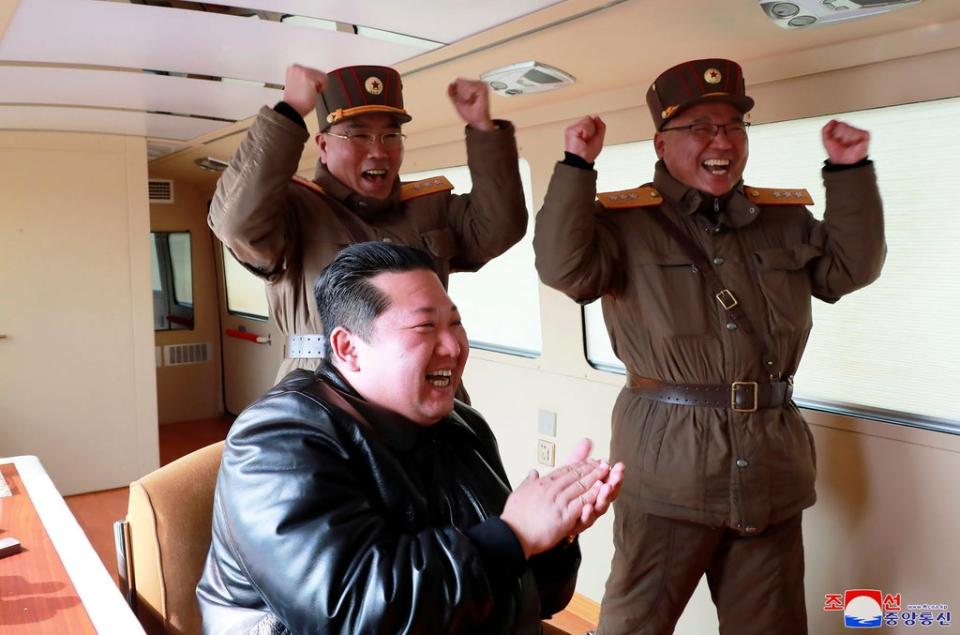 North Korean leader Kim Jong-un claps during a test-fire of what it says was a Hwasong-17 ICBM at an undisclosed location in North Korea on 24 March (Korean Central News Agency/Korea News Service via AP)