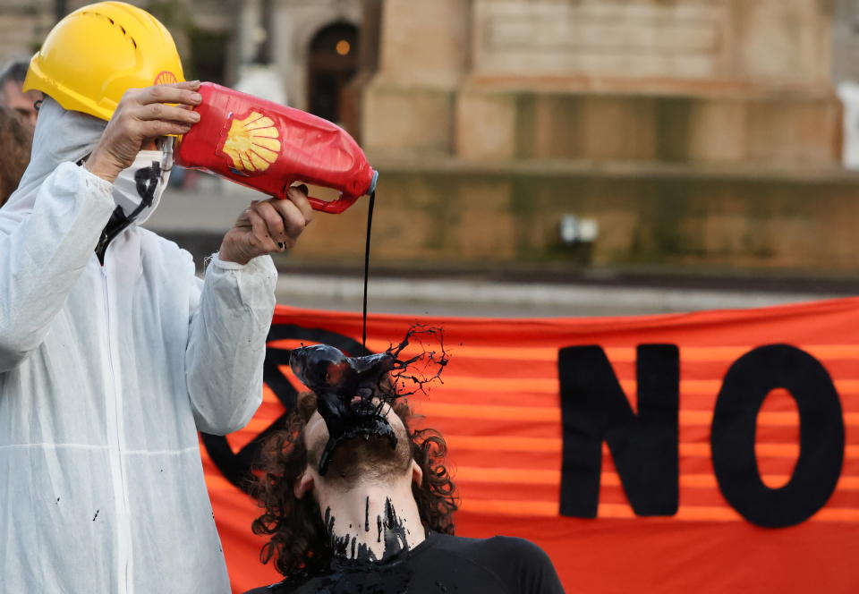 A man pours fake fuel on the face of a protester in Glasgow, Scotland.