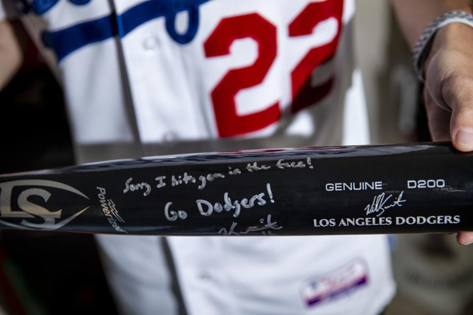 Austin Donley holds a bat signed by Dodgers catcher Will Smith bat.