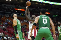 Miami Heat center Dewayne Dedmon (21) shoots over Boston Celtics center Enes Kanter (13) and forward Jayson Tatum (0) during the first half of a preseason NBA basketball game, Friday, Oct. 15, 2021, in Miami. (AP Photo/Lynne Sladky)