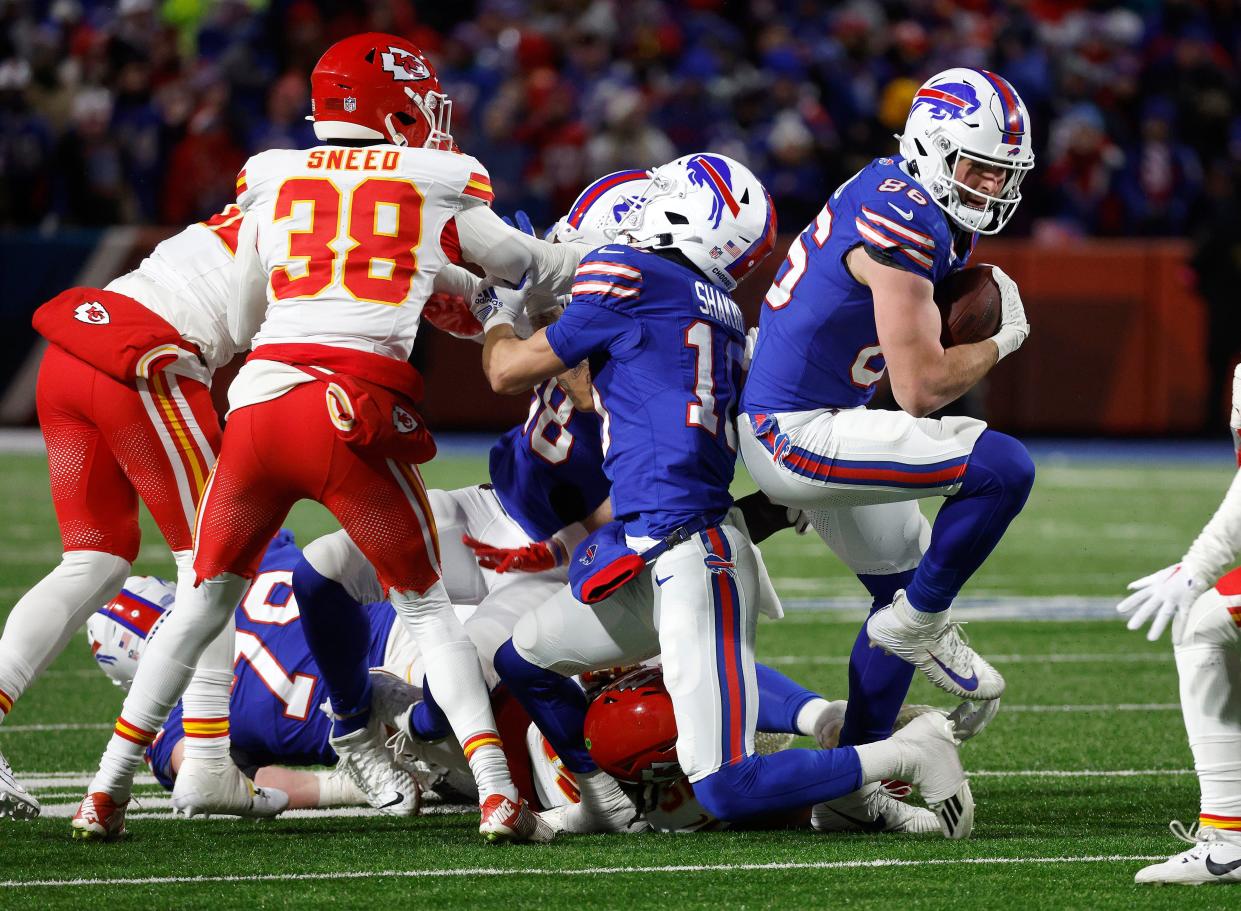 Buffalo Bills tight end Dalton Kincaid (86) slips though tacklers for extra yards after a catch.