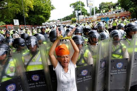 An opposition supporter shouts slogans in front of riot policemen during a rally to demand a referendum to remove President Nicolas Maduro in Caracas, Venezuela, June 7, 2016. REUTERS/Ivan Alvarado