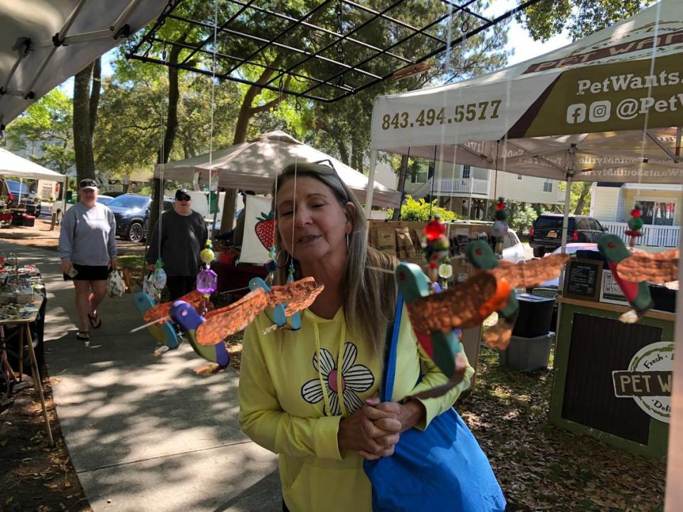 Terri Danielson of Myrtle Beach looks at artwork by Lori “Red” Varallo at the weekly Surfside Beach Farmers Market. Visitors enjoy fresh produce and local art at Myrtle Beach-area farmers markets this spring. April 11, 2023.