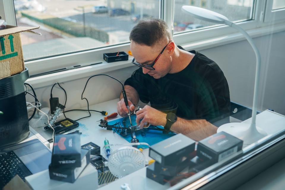 Vadim Ilchenko assembles a drone on his balcony. (Liza Pyrozhkova / The Kyiv Independent)