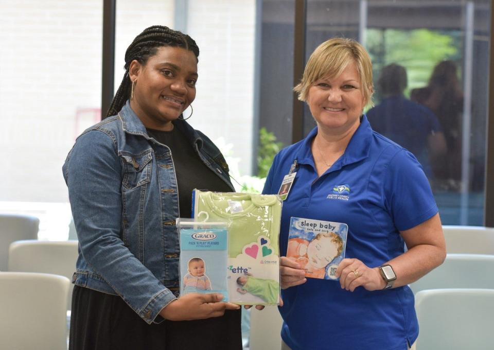 Chervon Crickie, left, and Sandusky County Public Health Nurse, Jane Molyet, hold some of the items new moms receive along with a free portable crib as part of the Cribs for Kids program.