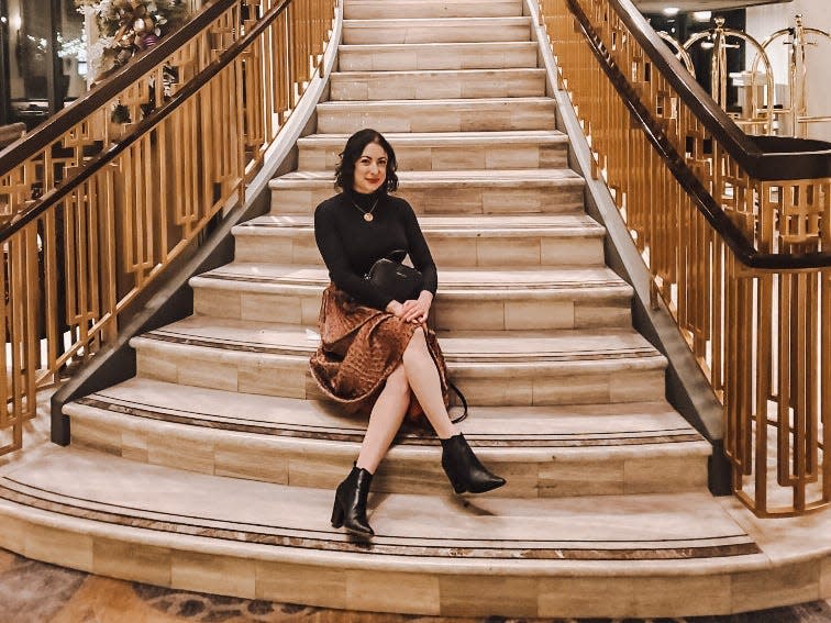 simone posing on the steps of the lobby stairs at the Fairmont empress hotel in victoria canada