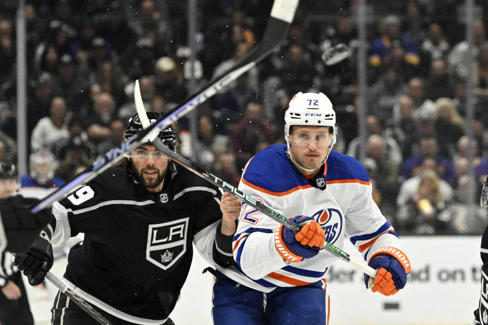 Edmonton Oilers center Nick Bjugstad, right, passes the puck while under pressure from Los Angeles Kings left wing Alex Iafallo during the first period of an NHL hockey game Tuesday, April 4, 2023, in Los Angeles. (AP Photo/Mark J. Terrill)