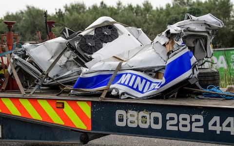 Remain of the minius, which was in two pieces, are pictured being removed from scene on the M1 motorway - Credit:  London News Pictures Ltd