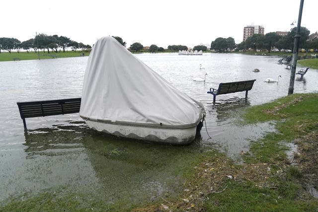 A boat washed up next to submerged benches in Southsea, Portsmouth 