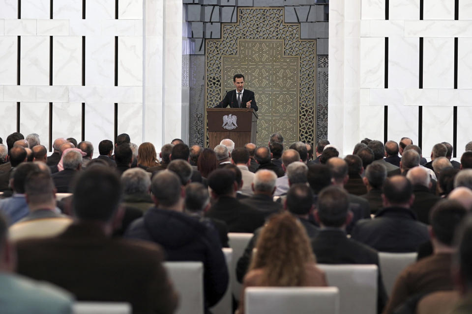 In this photo released by the Syrian official news agency SANA, Syrian President Bashar Assad, center, speak during meeting with heads of local councils from all Syrian provinces, in Damascus, Syria, Sunday, Feb. 17, 2018. Assad said that only the Syrian army can protect groups in northern Syria. In a speech he appeared to be referring to U.S.-allied Kurdish groups, which fear a Turkish assault once American troops withdraw from northeastern Syria. (SANA via AP)