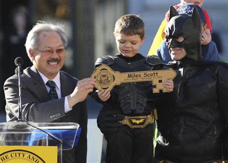 Five-year-old leukemia survivor Miles Scott, dressed as "Batkid" receive a key to the city declaring him "Junior Mayor" from San Francisco Mayor Ed Lee (L) during a ceremony as part of a day arranged by the Make- A - Wish Foundation in San Francisco, California November 15, 2013. REUTERS/Robert Galbraith