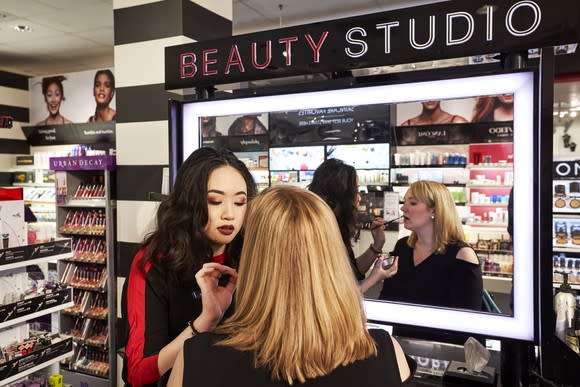 A woman having makeup applied by another woman at a Sephora salon inside a J.C. Penney.