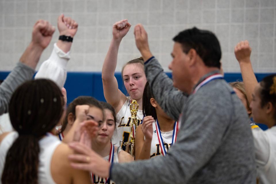 New Hope-Solebury's Reagan Chrenchik joins the huddle with their trophy at Bensalem High School on Saturday, Feb. 25, 2023. New Hope-Solebury girls basketball defeated Bristol in District One title game in class 3A, 53-28.